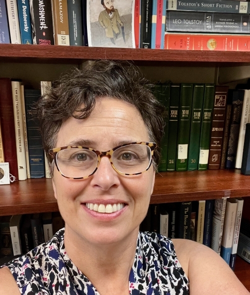 Woman smiling at camera with short black hair and glasses