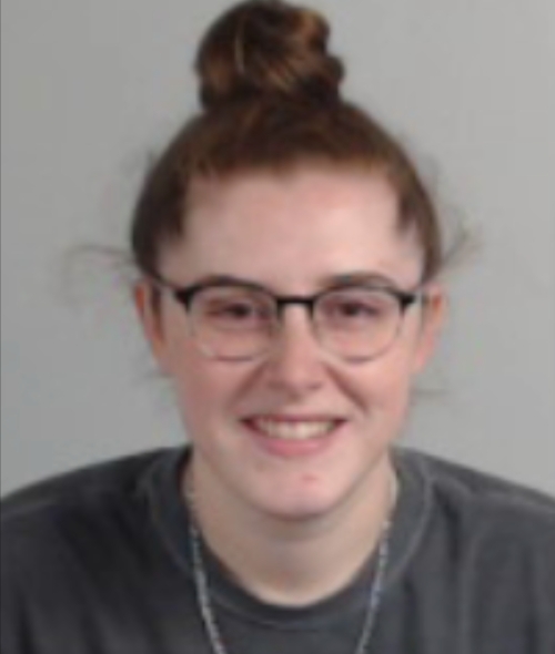 a young white woman wearing glasses with red hair in a bun