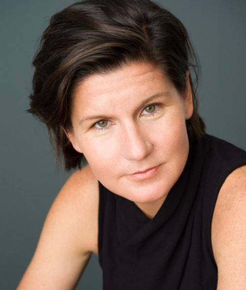 a middle aged white woman with short brown hair wearing a black sleeveless top