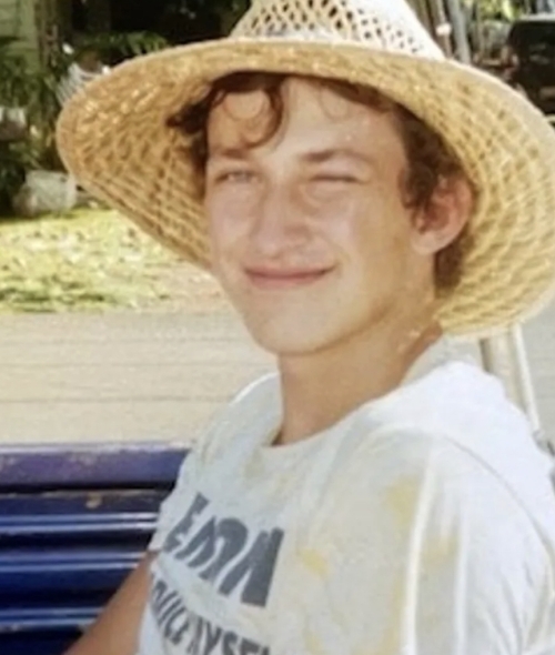 a young white male wearing a straw hat and t-shirt