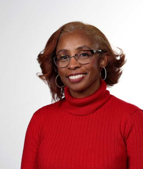 a young Black woman smiling wearing a red turtleneck sweater