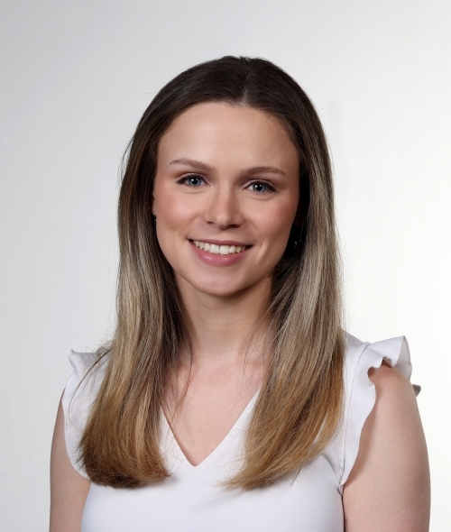 a young white woman with blonde hair wearing a white top