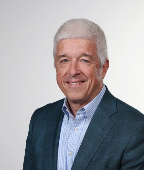 an older white man with white hair smiling