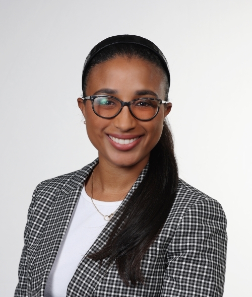 a young woman with black hair wearing glasses and a blazer