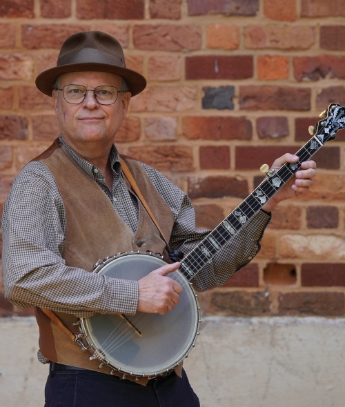 a middle aged white man playing a banjo