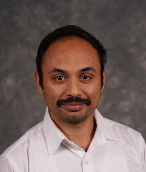an older man wearing a white collar shirt with a mustache