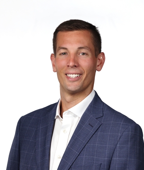 a young white man wearing a blue blazer and white shirt
