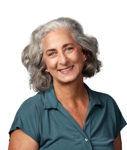 a middle aged white woman wearing a blue top with white hair