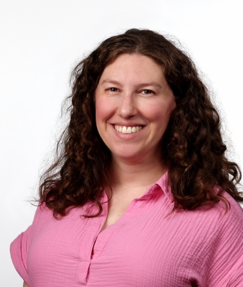 a young white woman with brown hair wearing a pink top