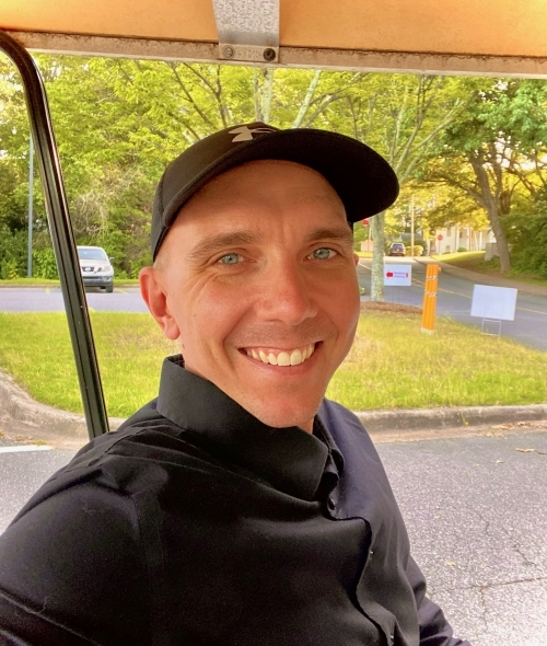 a middle aged man wearing a black shirt and hat