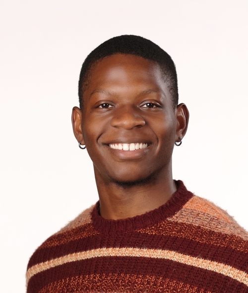 a young Black man wearing a striped sweater