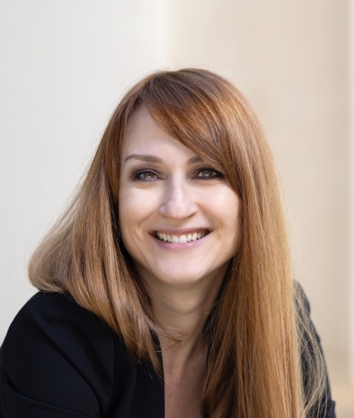 a middle aged white woman with red hair smiling