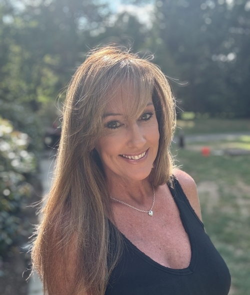 a middle aged woman with chestnut hair wearing a black top