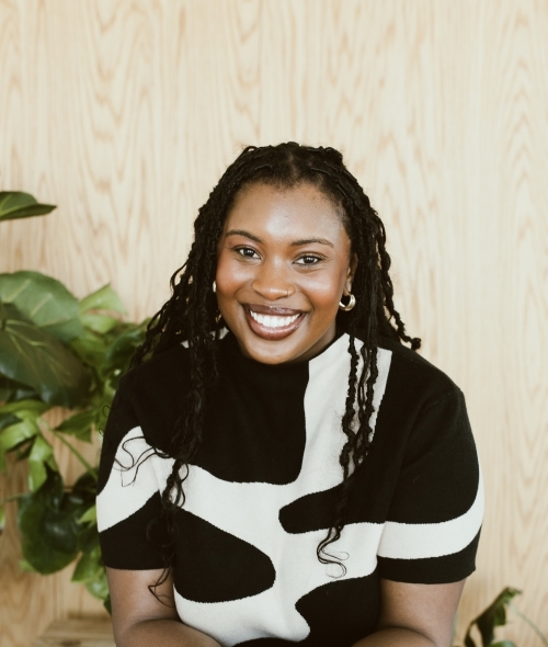 a young Black woman wearing a black and white top