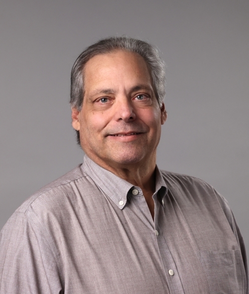 an older man wearing a collared shirt with grey hair