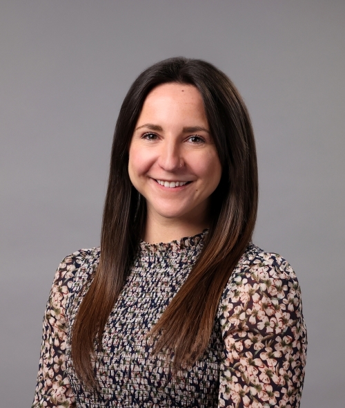a young white woman with brown hair wearing a floral top
