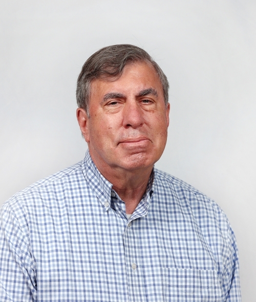 an older white man wearing a plaid collared shirt with grey hair