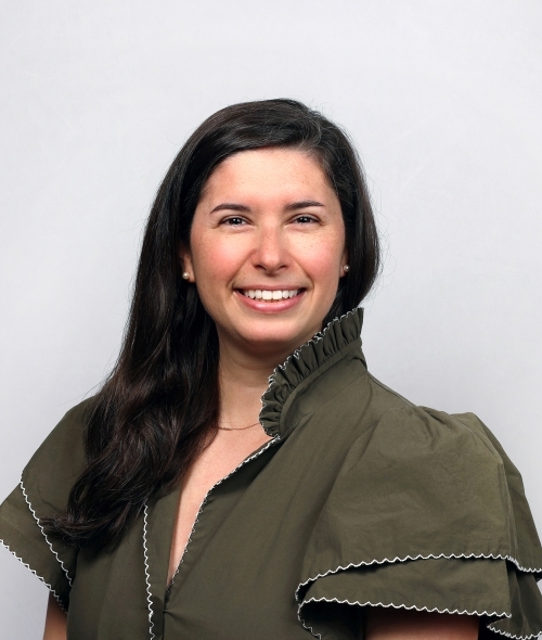 a young white woman with dark hair wearing a green dress
