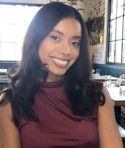 a young woman with dark hair wearing a red top