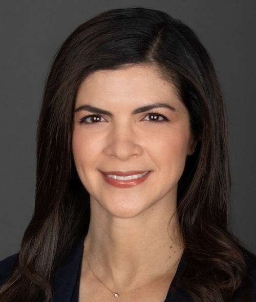 a young white woman with dark brown hair wearing a dark blazer