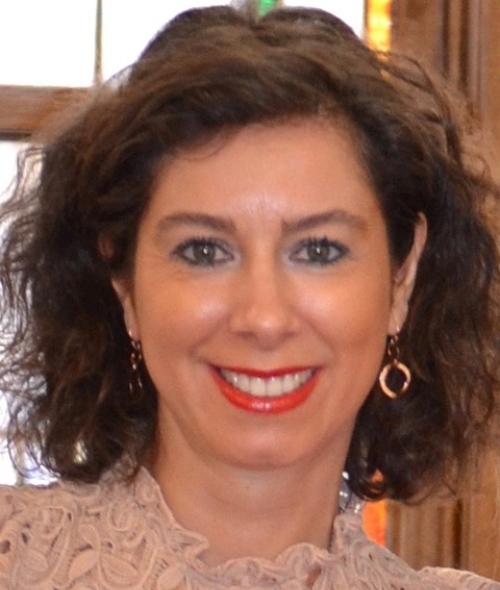 a middle aged woman with short curly brown hair