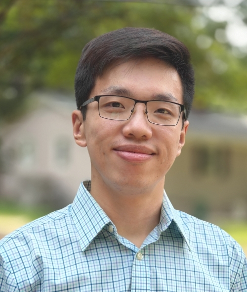 a young Asian man wearing a collared shirt and glasses