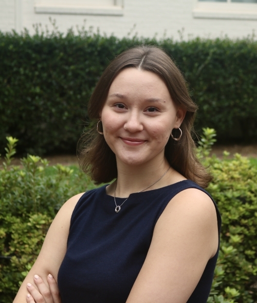 a young woman with short brown hair wearing a navy top