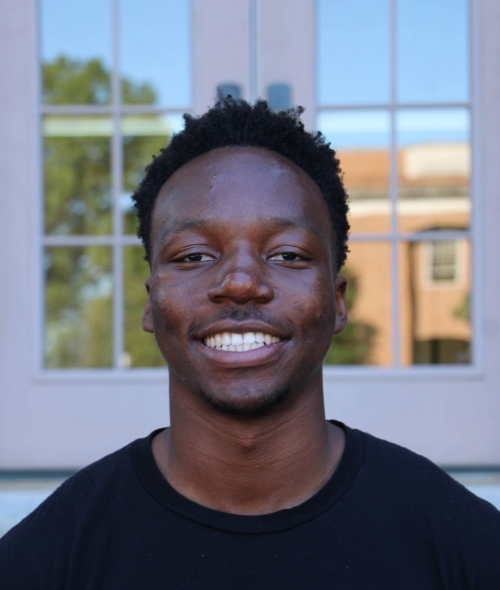 a young man wearing a Davidson College tshirt smiling