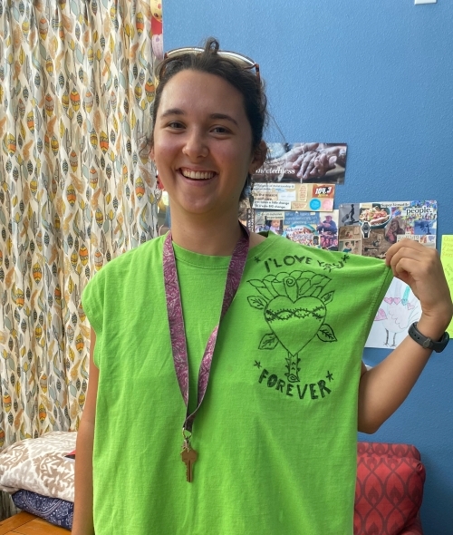 a young woman with curly brown hair wearing a lime green tshirt