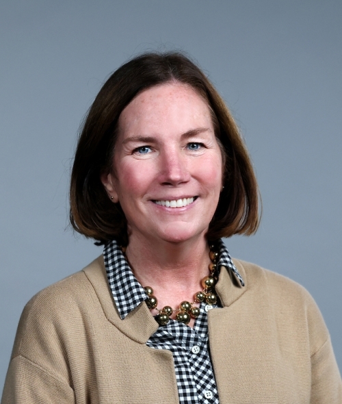 Adult caucasian woman with short dark brown hair and a tan sweater