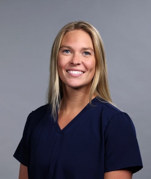 a woman with blonde hair wearing a navy blouse