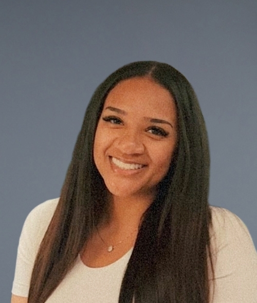 a young woman with long dark hair wearing a white shirt on a grey background