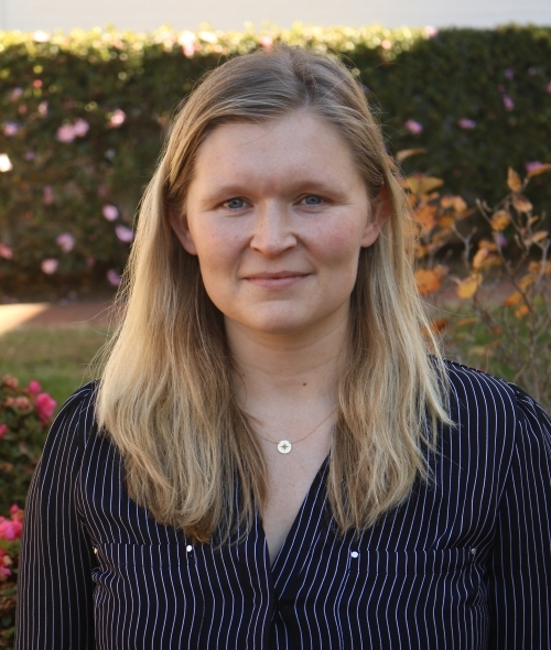 a white woman with blonde hair wearing a striped black top