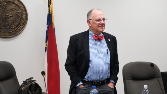 Bob Cordle stands in front of NC flag