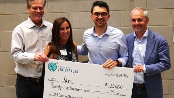 Shea Parikh and judges hold large check