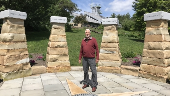 John Huie '60 stands inside stone monument