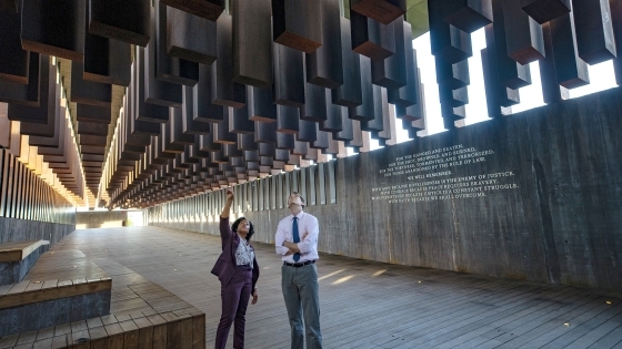 Two people stand and analyze the Equal Justice Initiative Museum exhibit