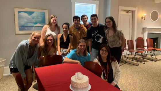 Students pose around a wedding cake