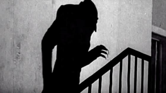 Halloween video screen shot of creepy shadow up the stairs