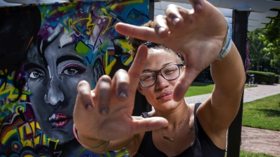 Student makes a square with her fingers, framing her face