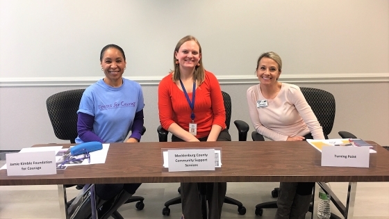 Alumni Elyse with two colleagues at support services table