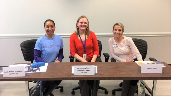 Alumni Elyse with two colleagues at support services table 