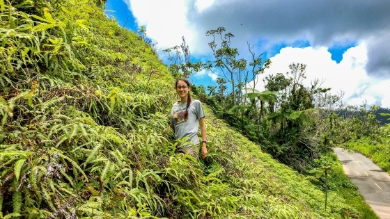 Lydia Soifer stands on a hill covered in vegetation