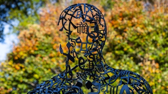 Campus sculpture with fall leaves in the background