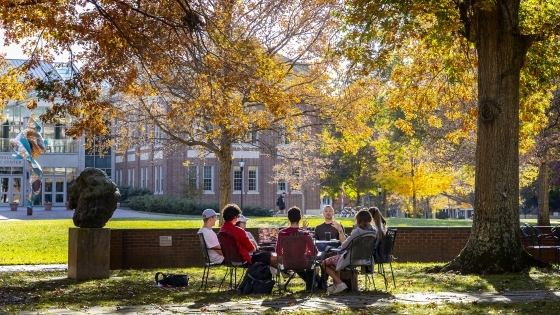 Prof. Patricio Boyer and Students gather outside on a beautiful fall day