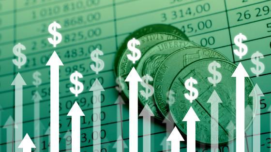 Arrows with dollar signs pointing upwards with spreadsheet ad coins in background