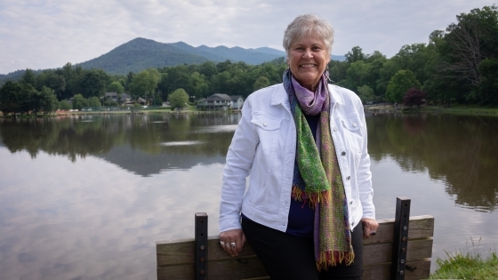 Ruth pittard smiles behind lake and mountains