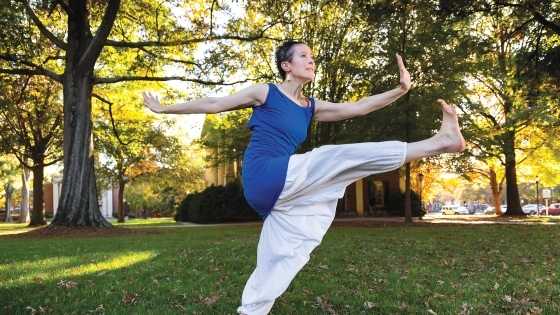 Davidson Dance Professor Dasha Chapman in Haitian dance pose outdoors