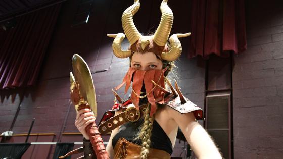 Emma Goldfarb '24 in theatre costume with 4 horns on her head and two-horned sledge-hammer in her hand