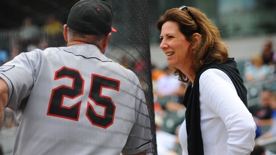 Back of Dick Cooke duriin baseball game with Susan leaning towards him 